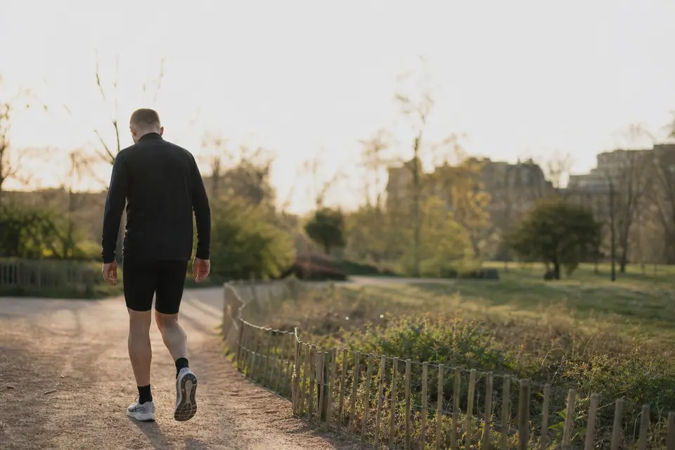Coureur marchant en récupération sur un chemin de parc après un effort d’endurance