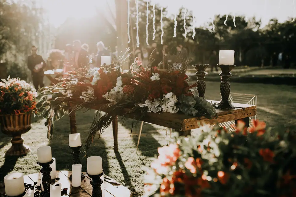 Tables de mariage fleuries assorties aux bougies, nappes beiges et chaises en bois clair