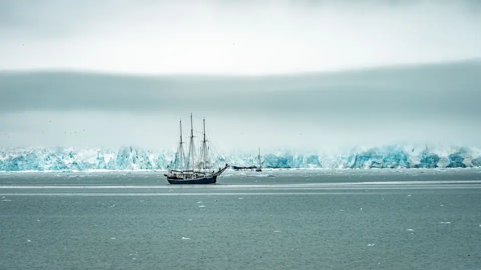 Scientifique en parka relevant le ciel nocturne depuis une station antarctique enneigée