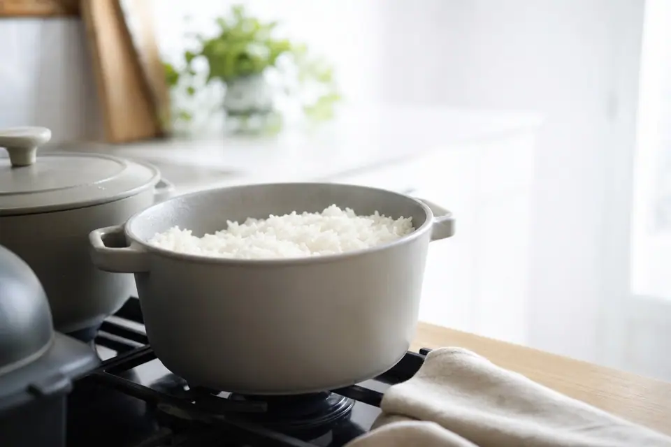Casserole de riz blanc cuit, grains détachés, posée sur une cuisinière