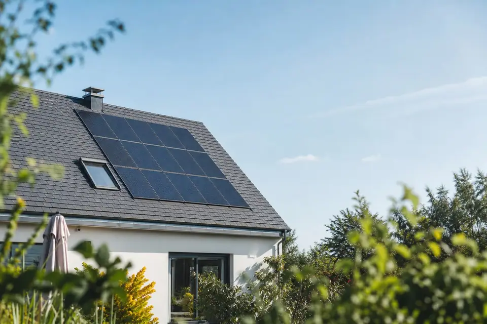 Panneaux photovoltaïques installés sur la toiture en pente d’une maison individuelle, ciel dégagé